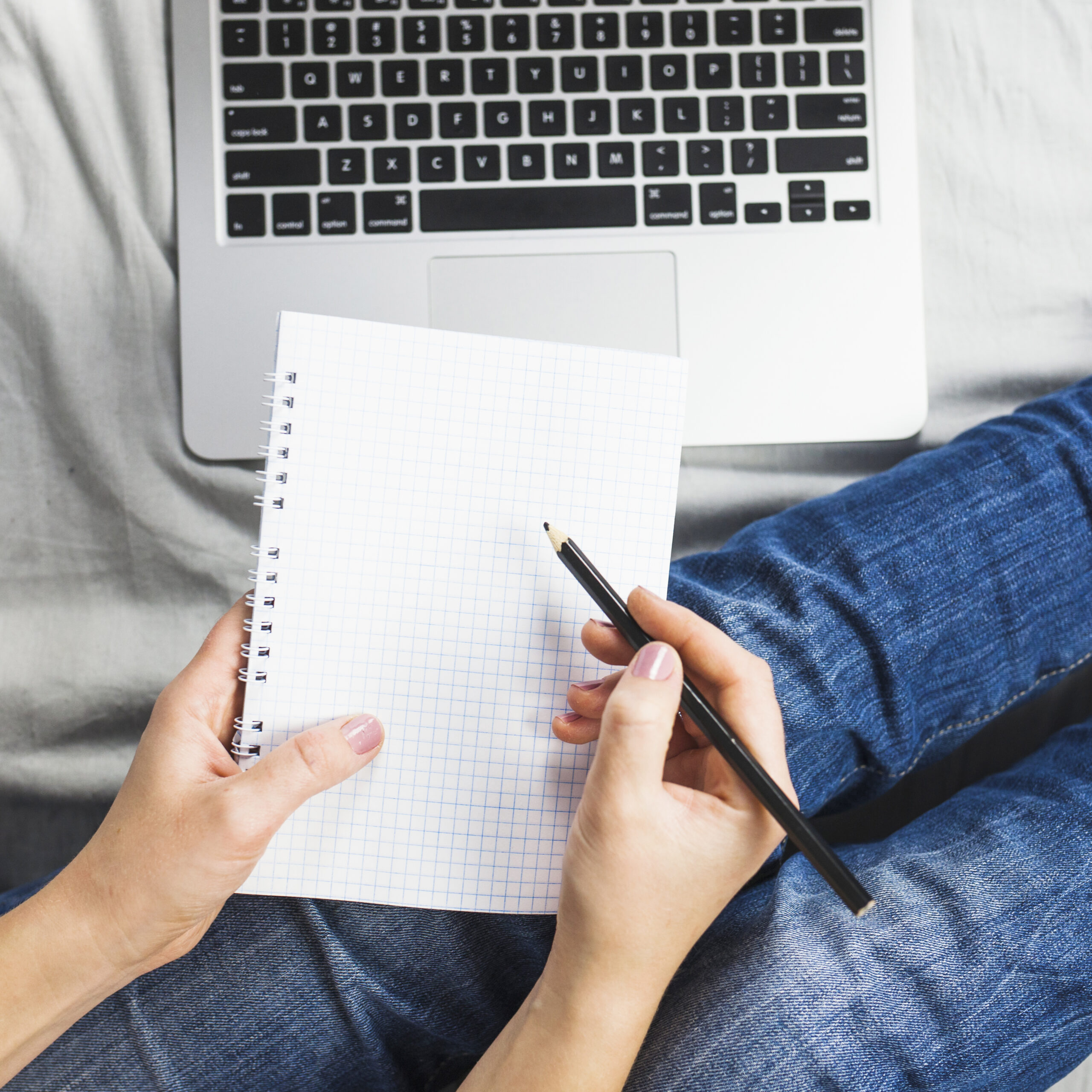 person-bed-with-laptop-notepad